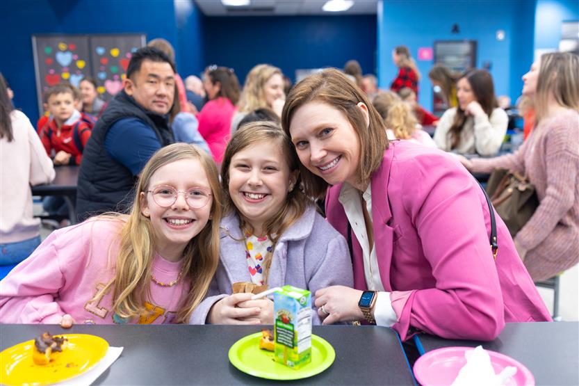 Creekside Elementary students eat donuts with a grown-up